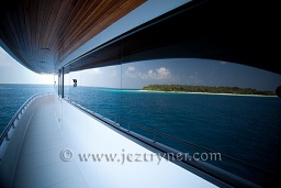 An island reflected in the windows of Sachika, North Ari atoll, Maldives, Indian Ocean, Asia.